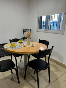 奇萊西托的住宿－Departamento Cristo del Portezuelo II，一张带黑色椅子的木桌和一张带鲜花的桌子