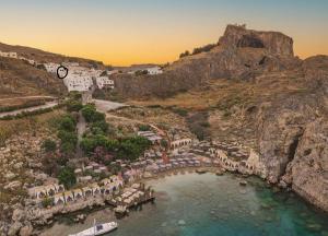 an aerial view of a beach with umbrellas and the ocean at Lindos 4 me Studios in Lindos