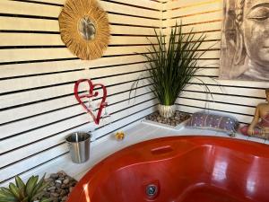 een rode badkuip in een hoek van een badkamer bij PAZ Y ARMONÍA en chuy 2 in Chuy