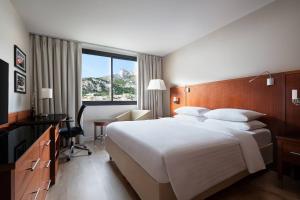 a hotel room with a large white bed and a desk at Riviera Marriott Hotel La Porte De Monaco in Cap d'Ail
