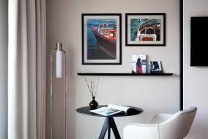 a living room with a table and a chair at Riviera Marriott Hotel La Porte De Monaco in Cap d'Ail