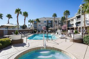 une piscine bordée de palmiers et un bâtiment dans l'établissement Courtyard by Marriott Henderson - Green Valley - Las Vegas, à Las Vegas