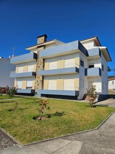 a large white building with a grass yard at Residencias Ana Carmen in Viana do Castelo