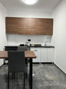 a kitchen with wooden cabinets and a wooden table at Star Apartments 1 in Novi Pazar