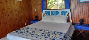 um quarto com uma cama com lençóis azuis e brancos em Villa U'upa em Uturoa