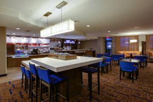 un restaurante con bar con taburetes azules en Courtyard Republic Airport Long Island/Farmingdale en Farmingdale