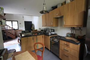 a kitchen with wooden cabinets and a black stove top oven at Maison Daubigny in Corne-Biche
