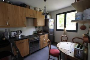 Corne-BicheにあるMaison Daubignyのキッチン(木製のキャビネット、テーブル付)