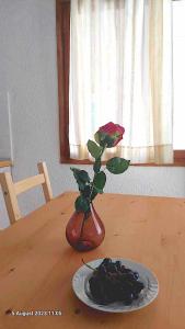 a vase with a rose and a plate of fruit on a table at Cozy & Comfort in Polykhrono