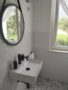 a white bathroom with a sink and a mirror at AGRITURISMO TERRAPIA in Moscufo
