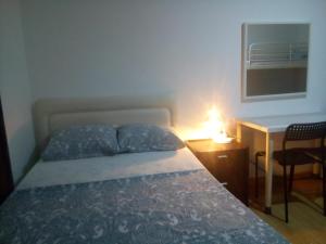 sypialnia z łóżkiem i biurkiem z lampką w obiekcie Guest House Sintra w mieście Queluz