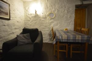 a living room with a table and a couch and a table and chair at Seal Cottage in Portnahaven
