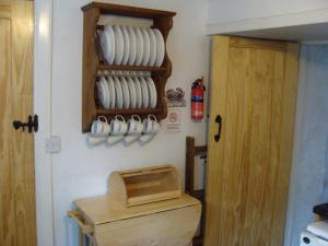 a kitchen with a counter with plates on a wall at Seal Cottage in Portnahaven +9 photos