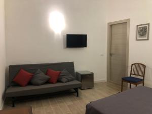 a living room with a couch and a tv on the wall at Kalé Atenea in Agrigento
