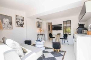 ein Wohnzimmer mit einem weißen Sofa und einer Küche in der Unterkunft Golfe St Tropez 3 pièces à 2 min de plage in Sainte-Maxime