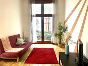 een woonkamer met een rode bank en een rood tapijt bij K13 fsz in Boedapest