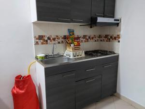 cocina pequeña con fregadero y fogones en Apartahotel Avenida Las Margaritas en Apartadó