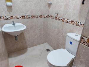 łazienka z toaletą i umywalką w obiekcie Apartahotel Avenida Las Margaritas w mieście Apartadó