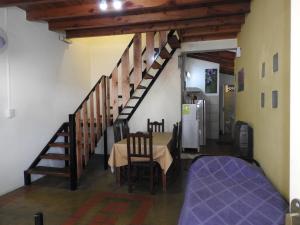 a living room with a table and a staircase at Los Girasoles team family in El Bolsón