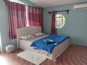 a bedroom with a bed with a blue comforter at Kaz Ami cozy home in Pereybere