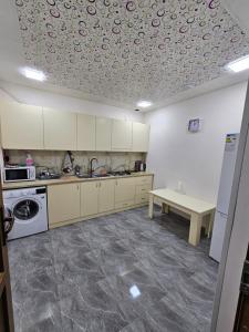 a kitchen with white cabinets and a table on the ceiling at Galstyans Home EVN Airport in Yerevan