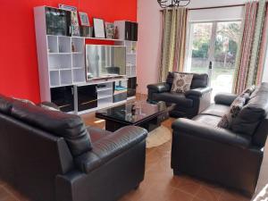 a living room with two leather chairs and a television at Kaz Ami cozy home in Pereybere