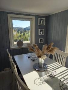 a dining room with a table and a window at Hytte Sørlandet med spa in Froland Verk