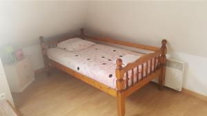 a bed with a wooden frame in a bedroom at Studio meublé centre ville de mer in Mer