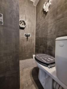 a bathroom with a toilet with a black lid at Fleur d'Or Proche ŔER C Evry in Brétigny-sur-Orge