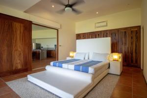 a bedroom with a large bed with two lamps at Condo BEACH FRONT PLAYA BLANCA GARDEN in Zihuatanejo