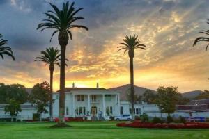 a white house with palm trees in front of it at Gorgeous Napa Valley Getaway - Steps from Wineries in Napa