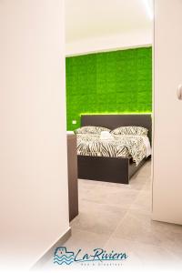 1 dormitorio con 1 cama con pared verde en La Riviera en Scalea