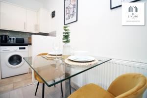 uma cozinha com uma mesa de vidro e cadeiras em Cosy Apartment In The Heart Of Uplands - Swansea - Prime Location - By EKLIVING LUXE em Swansea