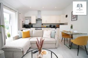 a living room with a couch and a table and a kitchen at Cosy Apartment In The Heart Of Uplands - Swansea - Prime Location - By EKLIVING LUXE in Swansea