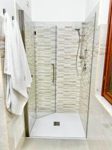 kabina prysznicowa ze szklanymi drzwiami w łazience w obiekcie la casa sul lago w mieście Scafa