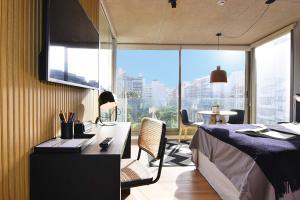 um quarto com uma cama, uma secretária e uma janela em Vistas Panorámicas al Parque em Montevidéu