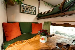 a living room with a couch and a table with a plant at Vintage '79 Bedford Wild Camping Truck near St Ives in Tuckingmill
