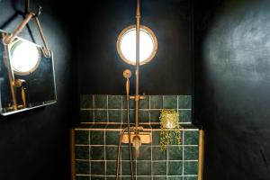 a bathroom with a shower with green tiles at Vintage '79 Bedford Wild Camping Truck near St Ives in Tuckingmill