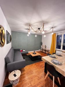 ein Wohnzimmer mit einem Sofa und einem Tisch in der Unterkunft Maison au calme avec Jardin proche Paris-Bercy in Charenton-le-Pont