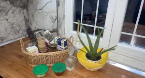 una mesa con una cesta y una planta y una ventana en Bujtina Rakaj en Bogë