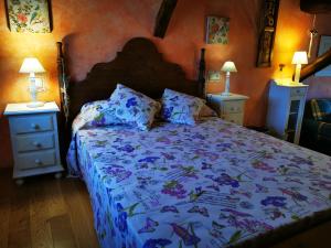 un letto in una camera da letto con due comodini e due lampade di Ático Pirón ad Adrada de Pirón