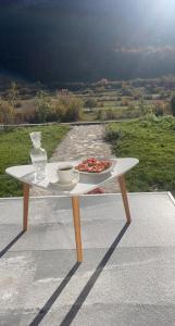 una mesa blanca con un plato de comida. en Bujtina Rakaj en Bogë