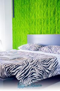 1 cama con estampado de cebra en un dormitorio con una pared verde en La Riviera, en Scalea