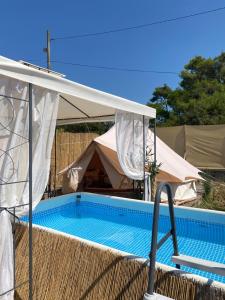 a swimming pool under a tent with a white canopy at Camping Perla in Zadar