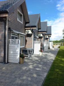 Casa con puertas blancas y patio en Domki Letniskowe RODOS, en Sarbinowo