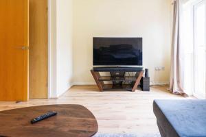 a living room with a television and a coffee table at Stylish 3 Bedroom and free parking in Thamesmead