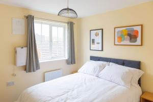 a bedroom with a white bed and a window at Stylish 3 Bedroom and free parking in Thamesmead