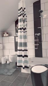 a bathroom with a black and white shower curtain at maria' s FeWo in Wallerfangen