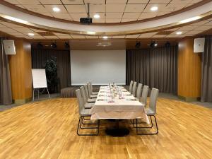 een vergaderzaal met een lange tafel en stoelen bij Hotel Venko in Dobrovo