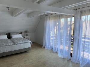 1 dormitorio con cama y ventana grande en Ferienhaus Igel, en Owingen